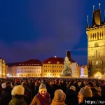 Home 19 체코의 신년맞이 행사 - A vibrant New Year's Eve scene at Prague’s Old Town Square, featuring a large crowd of joyful people...